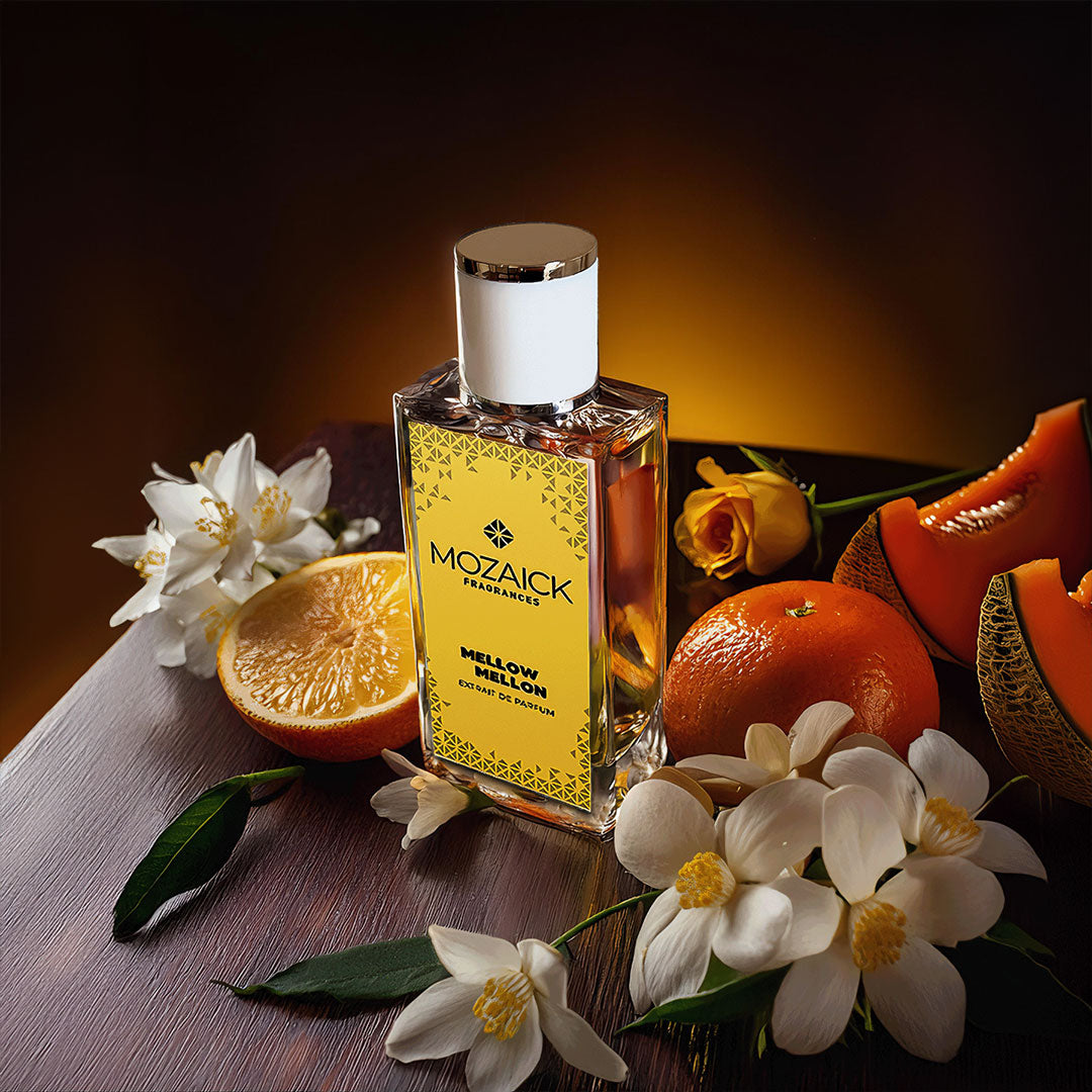 MELLOW MELLON Extrait de Parfum 50 ml by MOZAICK – bottle on a wooden table with melon, orange and white flowers